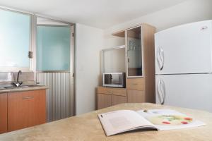 a kitchen with a refrigerator and a book on a table at Encantador Berlin By The Local Way in Mexico City