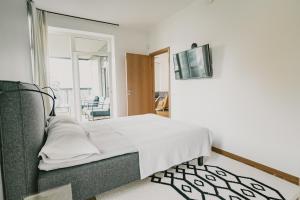 a bedroom with a bed and a tv on a wall at ÖÖ Street Luxury Apartment with Terrace in Tartu