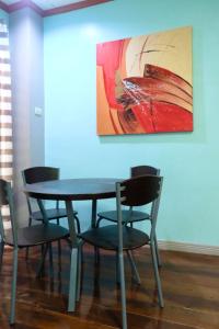uma mesa e cadeiras com um quadro na parede em Keyun's Inn- Across Cloud 9 em General Luna
