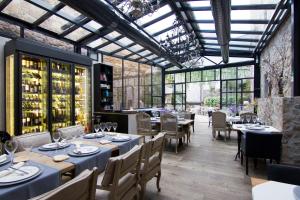 a restaurant with tables and chairs in a room with windows at Boutique Hotel Casa Granados in Tossa de Mar