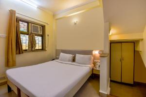 a bedroom with a large white bed and a window at Sereniity Resort Lonavala in Lonavala