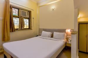 a bedroom with a large white bed and a window at Sereniity Resort Lonavala in Lonavala
