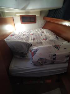 a unmade bed with pillows and a blanket on it at Boat in Badalona for up to 6 people in Badalona