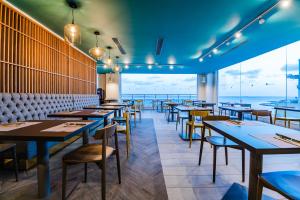 a restaurant with tables and chairs and a view of the ocean at Seaview Hotel - Adults Only 16 Plus in St Paul's Bay