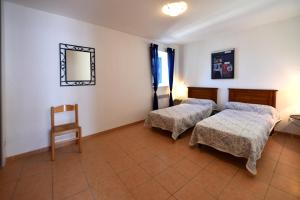 a room with two beds and a chair and a mirror at GITE DU COUVENT-Scala in Canari