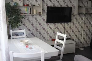 a dining room with a white table and two chairs at Stefanos Apartament in Baia Mare