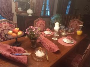 a dining room table with food and flowers on it at La Haie à Cerf in Watronville