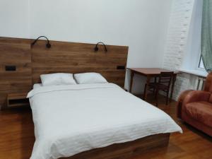 a bedroom with a large white bed and a chair at N.A.N. Apartments City Centre in Kyiv