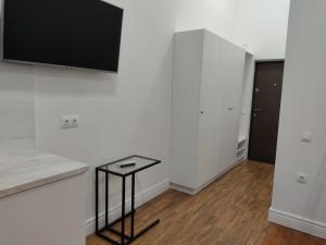 a kitchen with white walls and a black stool at N.A.N. Apartments City Centre in Kyiv