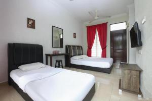 a hotel room with two beds and a window at Cerana Villa Eco Resort in Kota Bharu
