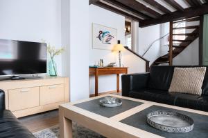 een woonkamer met een zwarte bank en een tafel bij De Soeten Inval in Middelburg