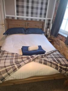 a bed with a blanket and two towels on it at Crosskeys Inn Guest Rooms in Wye Valley in Hereford
