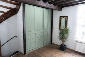 een slaapkamer met groene kasten en een potplant bij De Soeten Inval in Middelburg