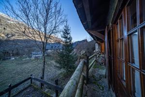 un edificio con una valla junto a un campo en Arties 3 habitaciones, en Arties