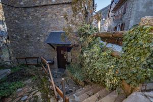 - un bâtiment en briques avec des escaliers menant à une porte dans l'établissement Arties 3 habitaciones, à Arties