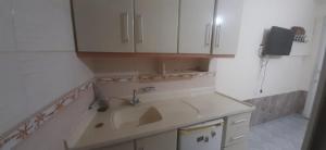 a kitchen with a sink and white cabinets at Atalay Pansiyon in Harbiye