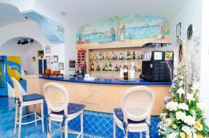 a bar in a restaurant with chairs and a counter at Hotel Terme Saint Raphael in Ischia