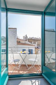 Habitación con vistas a un balcón con 2 sillas y una mesa. en Habitacions Bellaire Cadaqués en Cadaqués