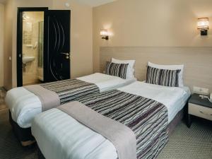 2 Betten nebeneinander in einem Hotelzimmer in der Unterkunft Aurora Hotel in Chabarowsk