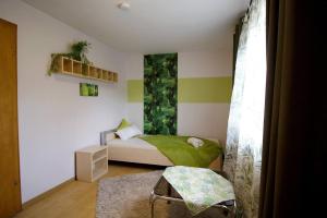 Habitación pequeña con cama y pared de acento verde en Work & Stay Apartment en Ulrichstein