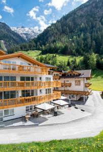 a hotel with a courtyard and mountains in the background at A Casa Saphir Appartement-Hotel in Sölden