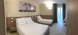 una habitación de hotel con 2 camas y una silla en TERRAZZA Rooms, en Castrezatto