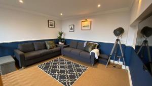 a living room with a couch and a camera at Spacious luxury flat in Swanage, close to beach in Swanage