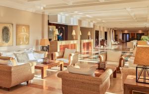 a lobby with couches and chairs in a building at Hotel Las Madrigueras Golf Resort & Spa - Adults Only in Playa de las Americas