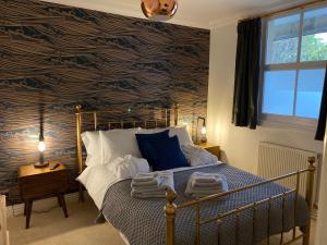 a bedroom with a bed with a blue and black wall at Spacious luxury flat in Swanage, close to beach in Swanage