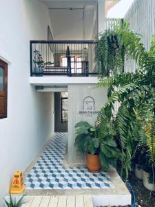 un couloir avec des plantes et un balcon dans un bâtiment dans l'établissement Baan Chiang Bed Lampang, à Ban Nam Thong