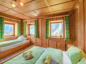 a room with two beds in a wooden cabin at FERIENHAUS BERGBLICK 10-25 PERS Urig, echt & perfekt für Familien und Freunde Ideal für unvergessliche Tage mit traumhaftem Bergpanorama in Längenfeld +17 photos