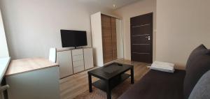 a small living room with a tv and a table at Apartament Gdynia Kazart.Pl in Gdynia