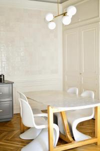 une salle à manger avec une table blanche et des chaises blanches dans l'établissement Eden blue, Lovely flat, bright & cosy in Lyon, à Lyon