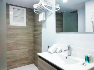 ein Bad mit einem Waschbecken und einem Spiegel in der Unterkunft Hotel Flats Friends Mar Blau in Benidorm