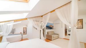 sypialnia z białymi zasłonami, łóżkiem i wanną w obiekcie Villa Ambra 10, Emma Villas w mieście Sorso +37 zdjęć