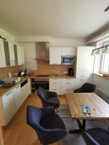 cocina con armarios blancos y mesa de madera en Haus mit Traumhaften Ausblick, en Villach