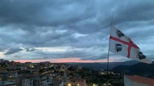 a flag on a building with a city in the background at Orgosolo B&B Sardegna in Orgosolo