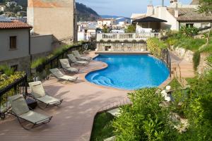 einen Pool mit Liegestühlen neben einem Gebäude in der Unterkunft Boutique Hotel Casa Granados in Tossa de Mar