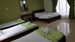 a room with three beds and a mirror at Cerana Villa Eco Resort in Kota Bharu
