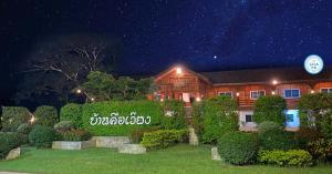 una casa di notte con un cartello davanti di Baan Khue Wieng Resort a Mae Sariang