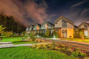 a house at night with its lights on at Baltic Natur Park - Holiday Resort in Niechorze