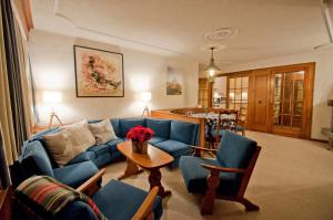 sala de estar con sofá azul y sillas en Haus Viktoria A, Apartment Blauherd, en Zermatt