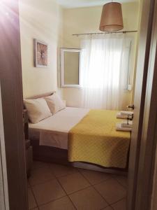 a small bedroom with a bed and a window at Sunny summer time in Nea Vrasna
