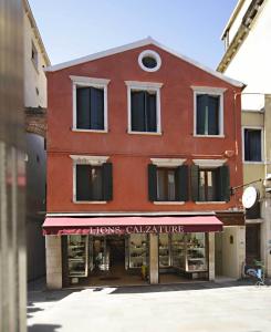 un gran edificio rojo con una tienda delante en Hotel Adriatico en Venecia