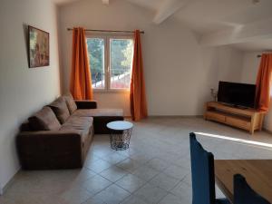 uma sala de estar com um sofá e uma televisão em Villa Dervonnae, la Provence à l'ombre des Chênes em Tavernes