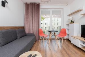 een woonkamer met een bank, stoelen en een tafel bij Rewita Wrzeszcz Apartments by Renters in Gdańsk
