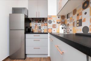 a kitchen with white cabinets and a refrigerator at Rewita Wrzeszcz Apartments by Renters in Gdańsk