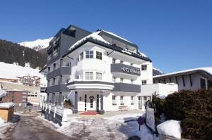 a large white building with snow on the ground at Hotel Germania in Ischgl