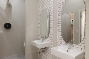 een witte badkamer met 2 wastafels en een spiegel bij THE BELONG BOUTIQUE HOTEL in Phuket