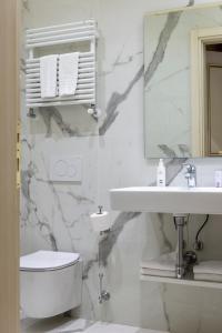 a bathroom with a sink and a toilet and a mirror at Hotel Antico Doge - a Member of Elizabeth Hotel Group in Venice